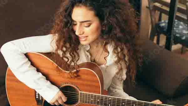 write-a-topline-melody Woman Singing While Playing Guitar