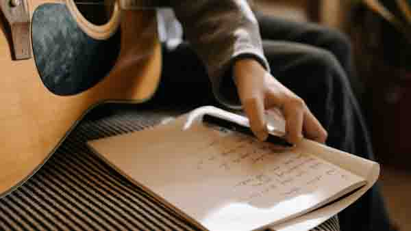 writing-song-lyrics Person With Guitar and Notepad
