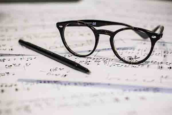 how-to-structure-a-song Glasses and a Pen on Top of Sheet Music