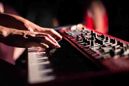 piano-chord-inversions Hands Playing a Red Synthesizer Piano