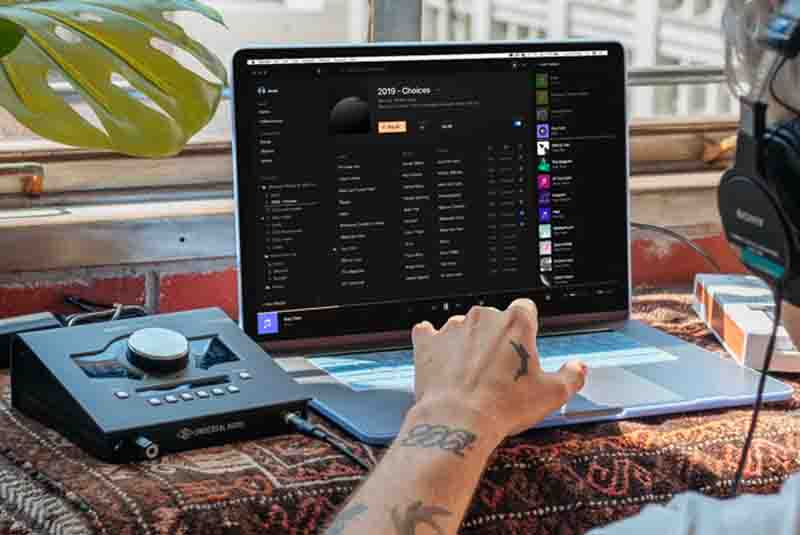 Laptop-Audio-Recording Hand on a Macbook Laptop Next to an Audio Interface