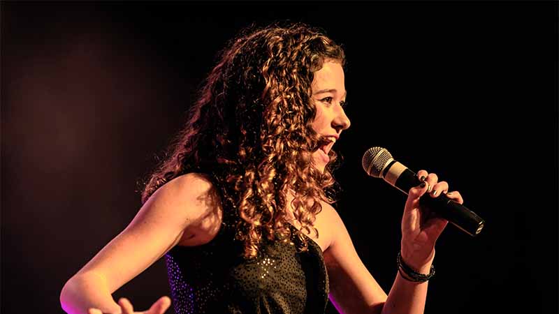 how-to-sing-vibrato Woman Singing Vibrato On Stage